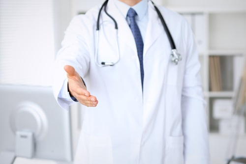Врач в белом халате протягивает руку
